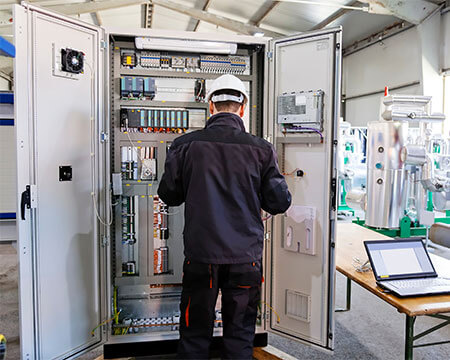 Man working on an industrial control panel