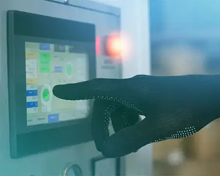 Worker hand in a black glove presses on the touch screen control panel equipment in the factory. Control machine operating parameters via touch screen. Worker hand at the workplace.